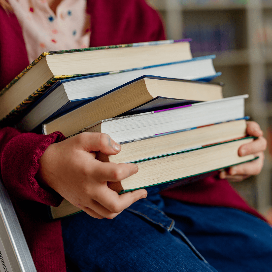 Pige med bog i bibliotek – aktiviteter for børn i Aarhus til stille stunder