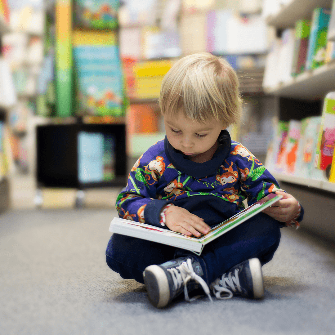 Dreng læser stille på biblioteket – rolige aktiviteter for børn i Odense med fordybelse