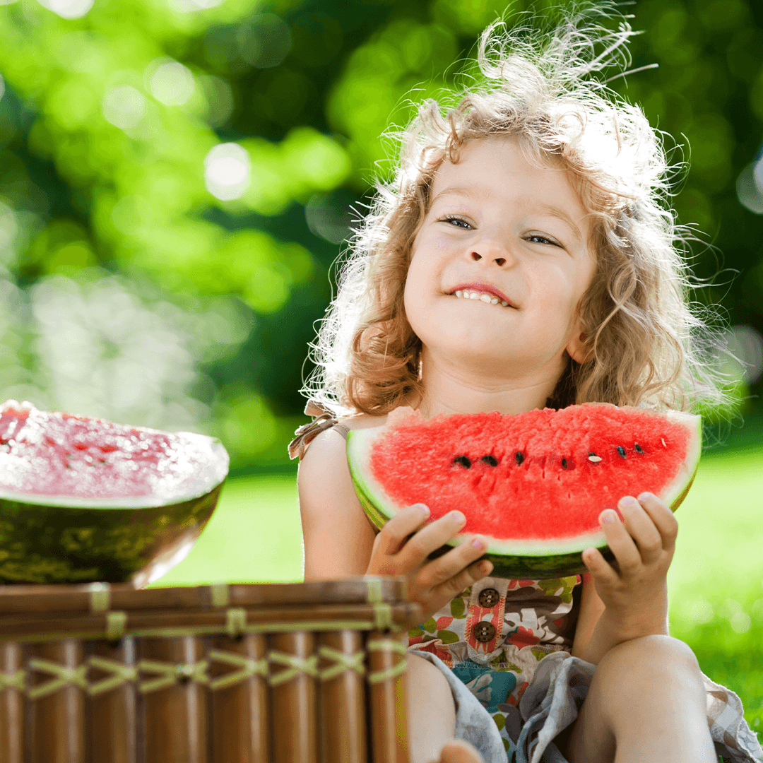Barn nyder melon i solen – sommerlige aktiviteter for børn i Aarhus med picnic og leg