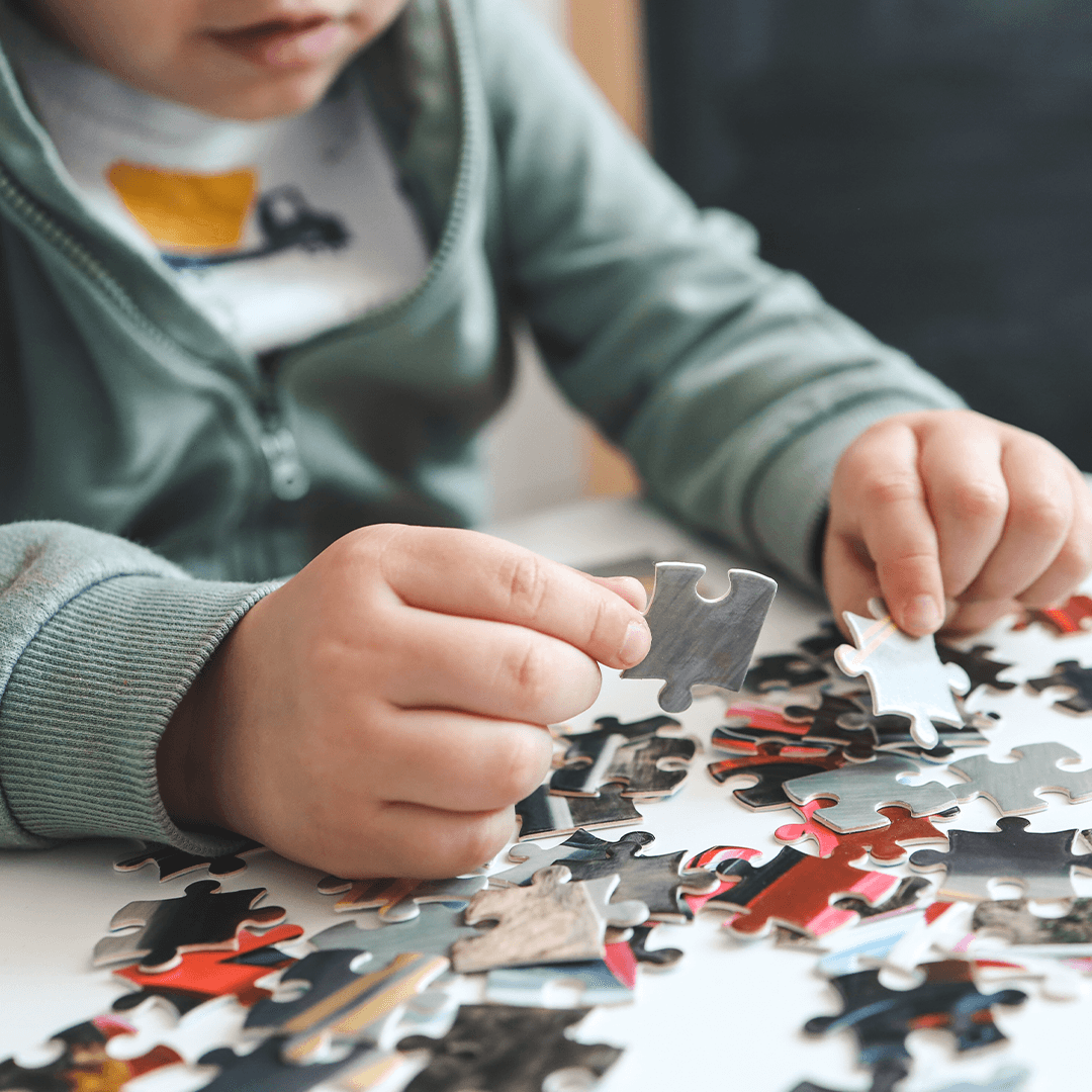 Kind legt Puzzle, Bewegung Kind fördert Feinmotorik