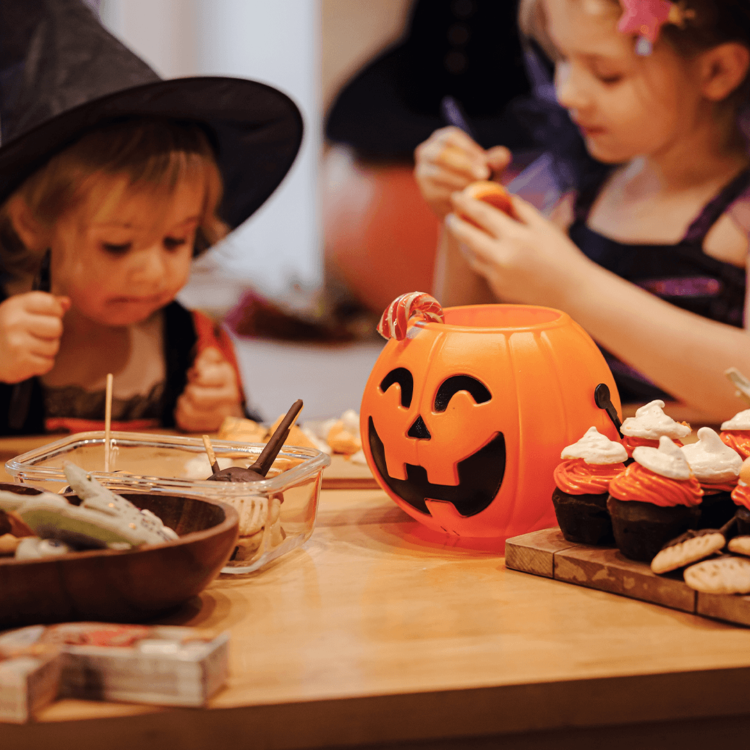 Børn dekorerer halloweenlækkerier sammen
